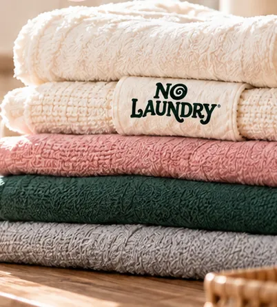Folded cream, pink, green and grey towels with a NoLaundry label